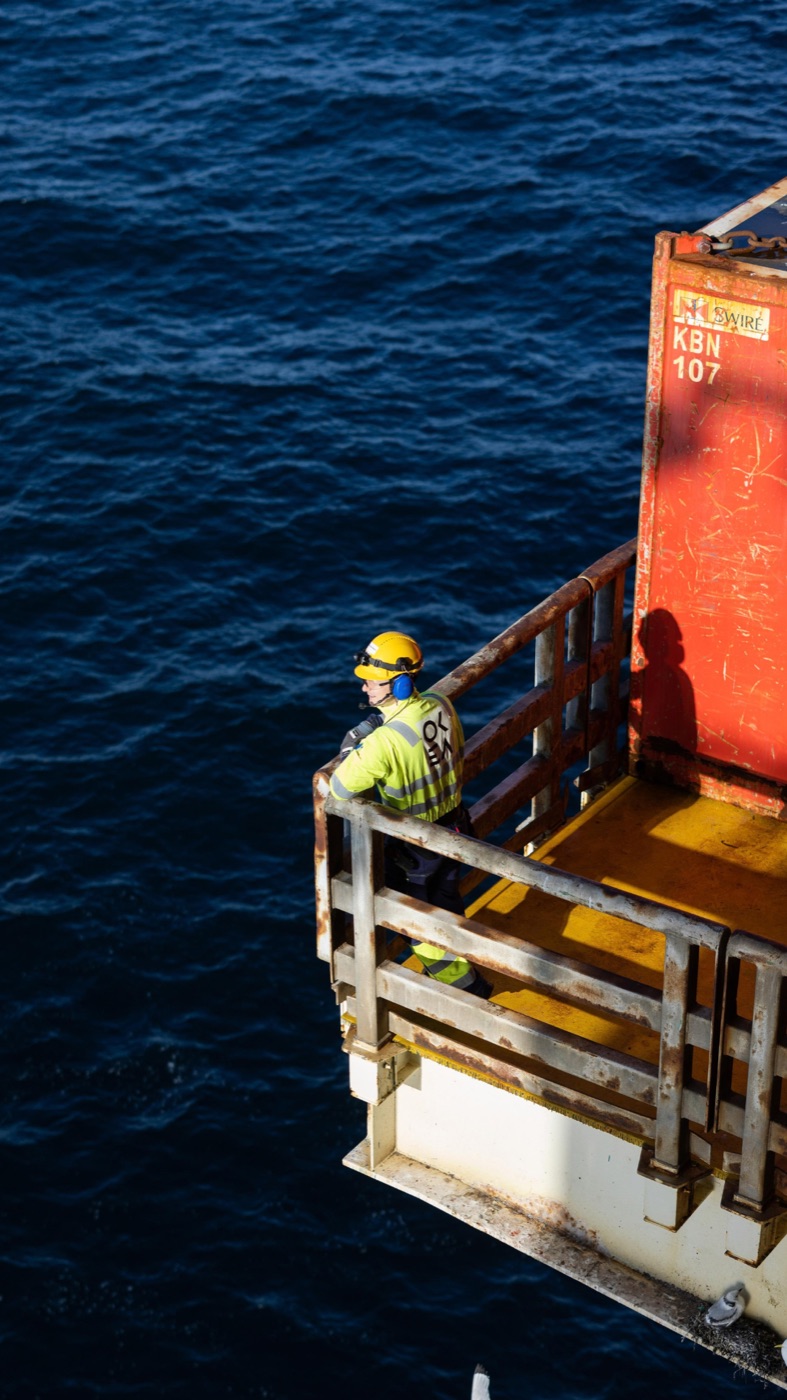 Person i verneutstyr på en offshoreinstallasjon med havet i bakgrunnen
